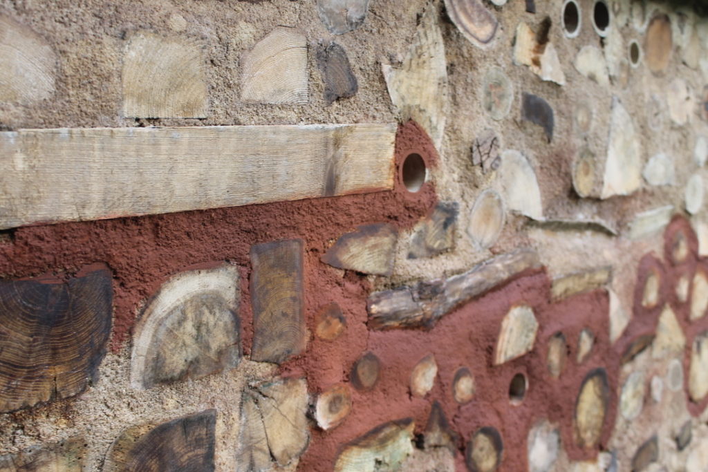Portion d'un mur en bois cordé avec utilisation de mortier coloré avec du pigment terre de Sienne